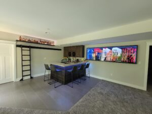 finished basement with custom wood framed sports jerseys and bar cabinets