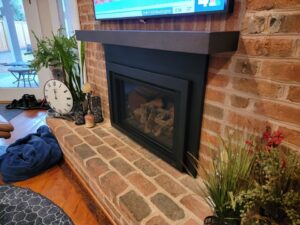 custom dark brown wood mantel placed above black fireplace